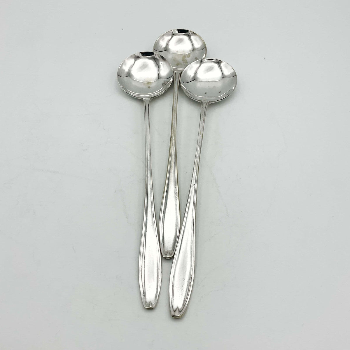 Set of silver-plated long-handled dessert spoons from Beeches Vintage, showcasing elegant, shiny finishing and elongated handles.