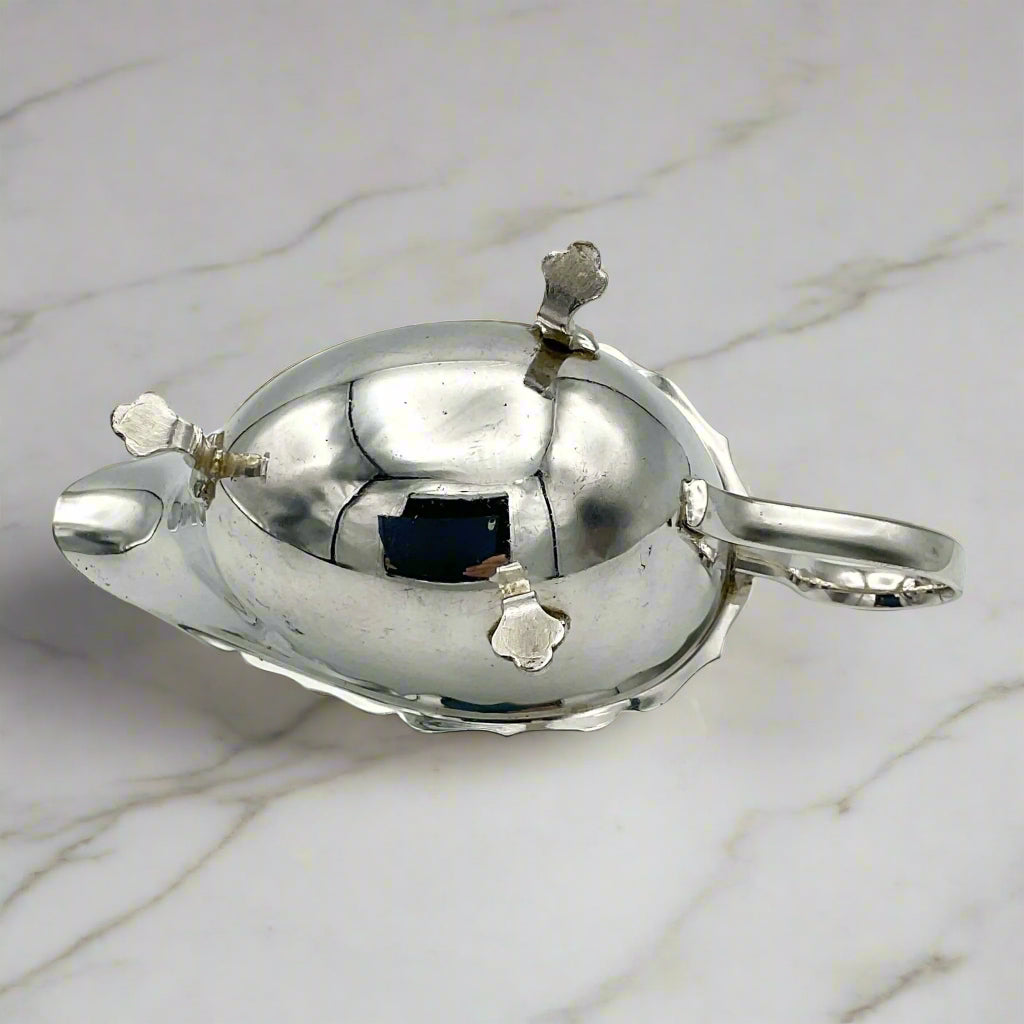 silver plated gravy boat upside down on a light marble worktop