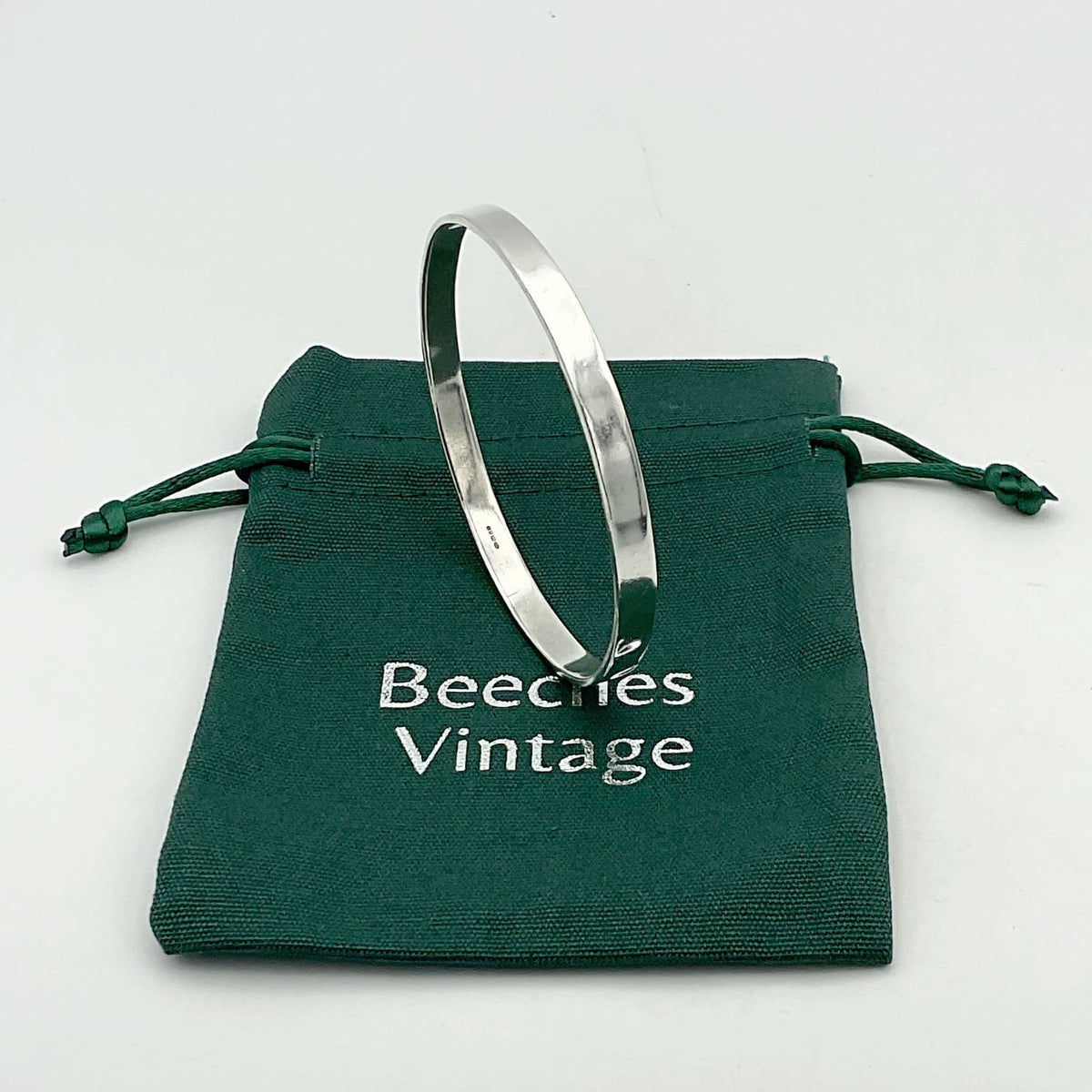 Sterling silver bangle bracelet from Beeches Vintage, showcasing a smooth, polished solid silver design with subtle craftsmanship details.