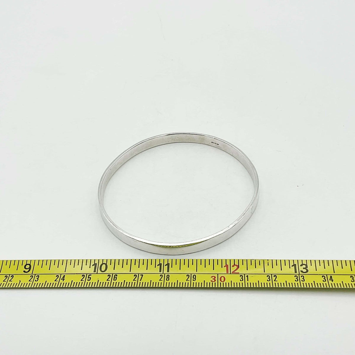 Sterling silver bangle bracelet by Beeches Vintage with smooth, polished surface and rounded edges, stylish jewelry accessory.