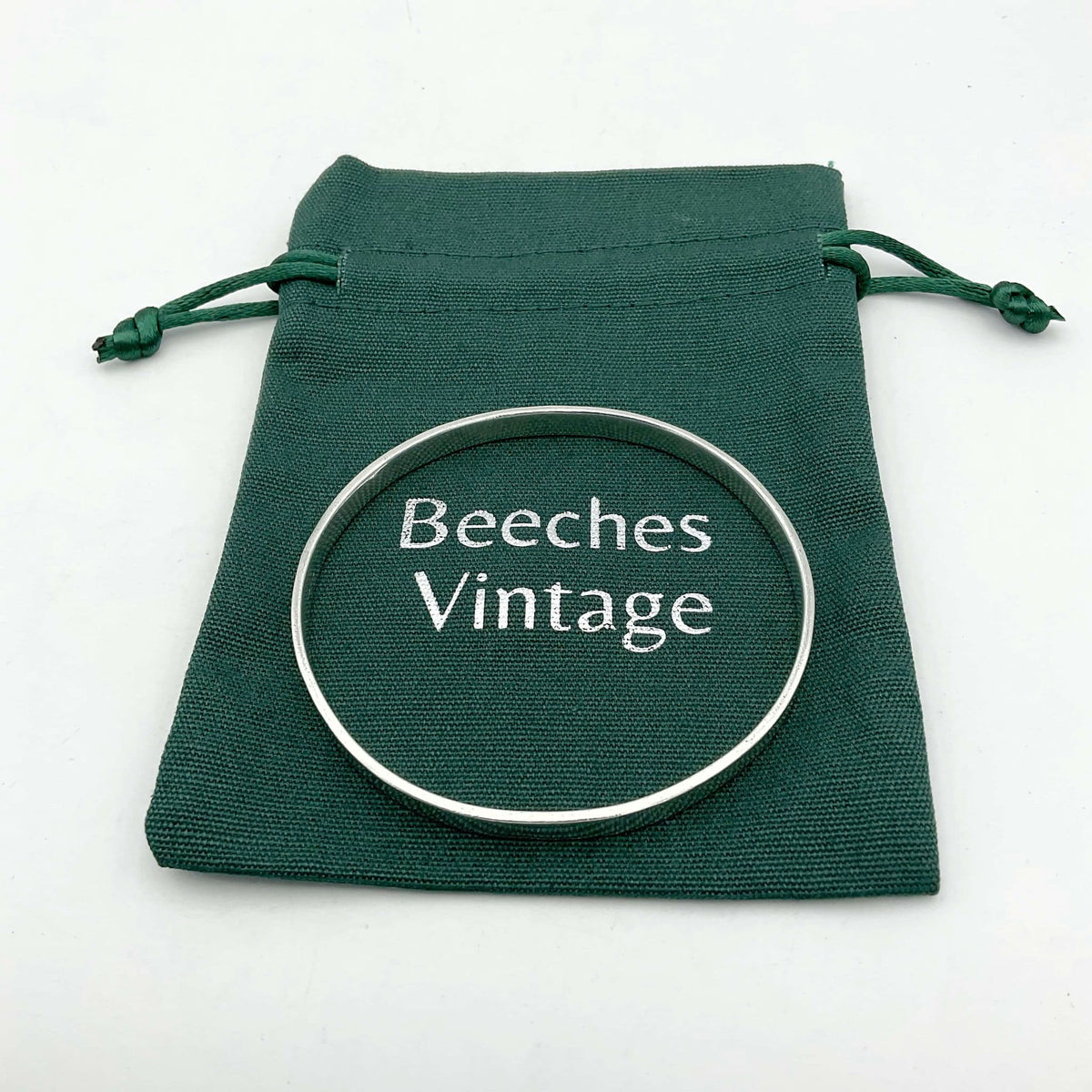 Solid sterling silver bangle bracelet by Beeches Vintage, showcasing a smooth, polished round design with a secure clasp.