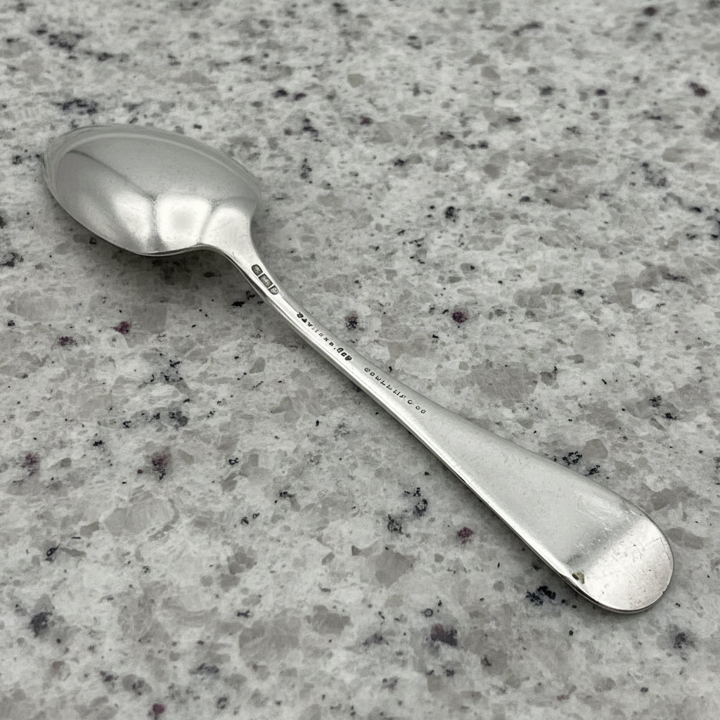 Silver spoon upside down on a gray granite surface