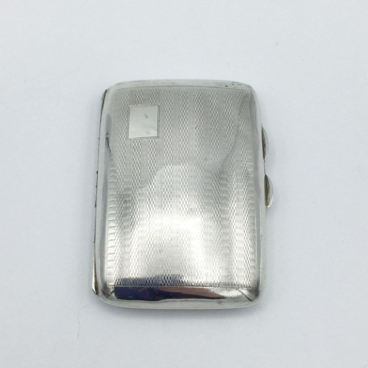 a shiny vintage art deco style sivler cigarette case on a white background