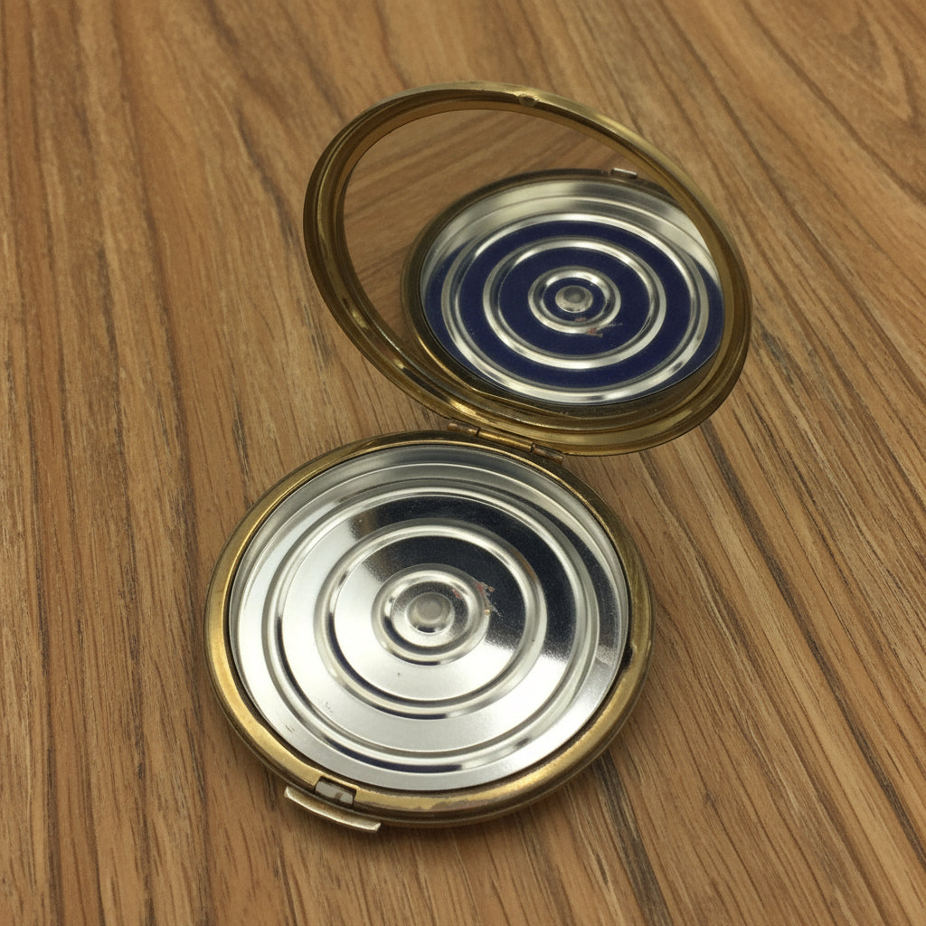 open Stratton compact showing clear mirror and inner base on wood table
