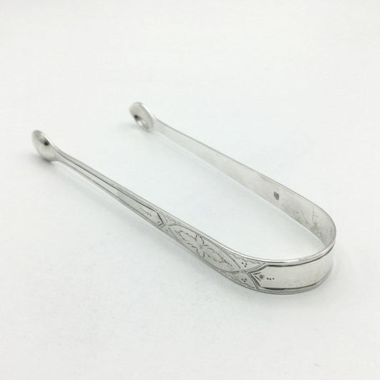 1700s Silver sugar tongs with a pretty floral engraved design on a white background