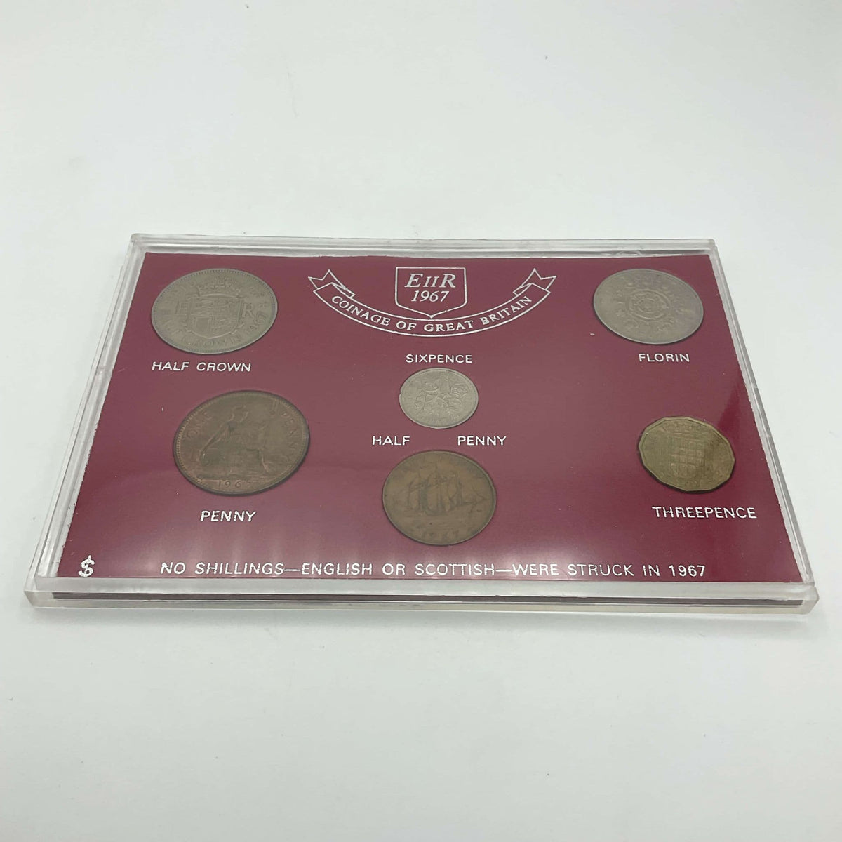 Six pre decimal currency coins in a red case