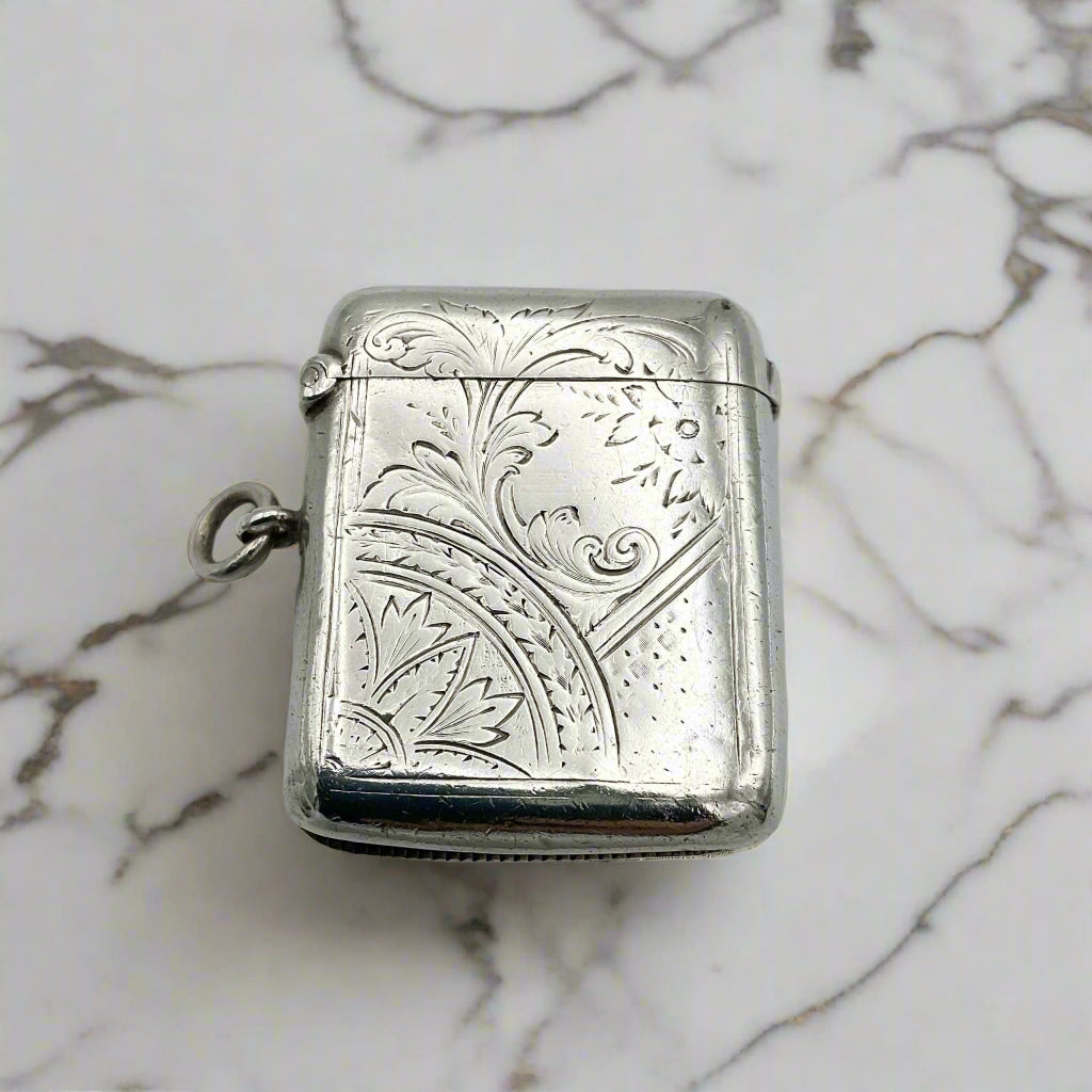Silver engraved compact on a marble surface