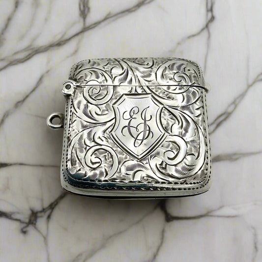 Antique sterling silver Vesta case with art nouveau design and a shield with EJ engraved in the centre, featuring a loop on one side.