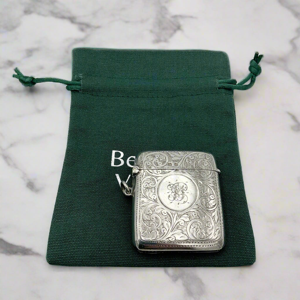 Silver vesta on a green drawstring pouch with 'Beeches Vintage' branding on a marble background