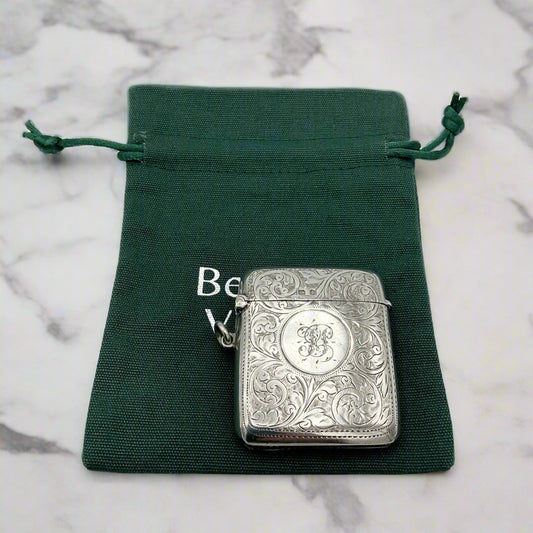Silver vesta on a green drawstring pouch with 'Beeches Vintage' branding on a marble background