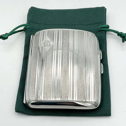 Antique 1920s silver cigarette case on a green cotton bag